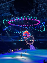 an ice skating rink with colorful lights in the background
