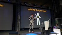 a man in a suit standing on a stage